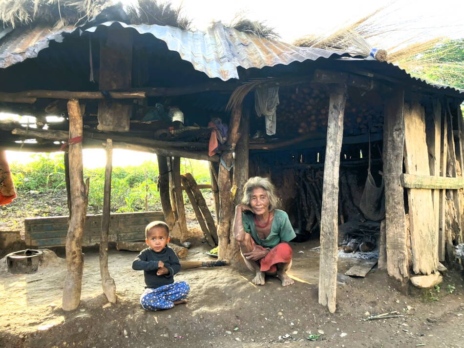 Chepang Frau mit Enkelkind vor ihrem Haus