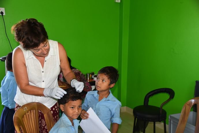 Volunteer Christine Bacchetto checking children for lice